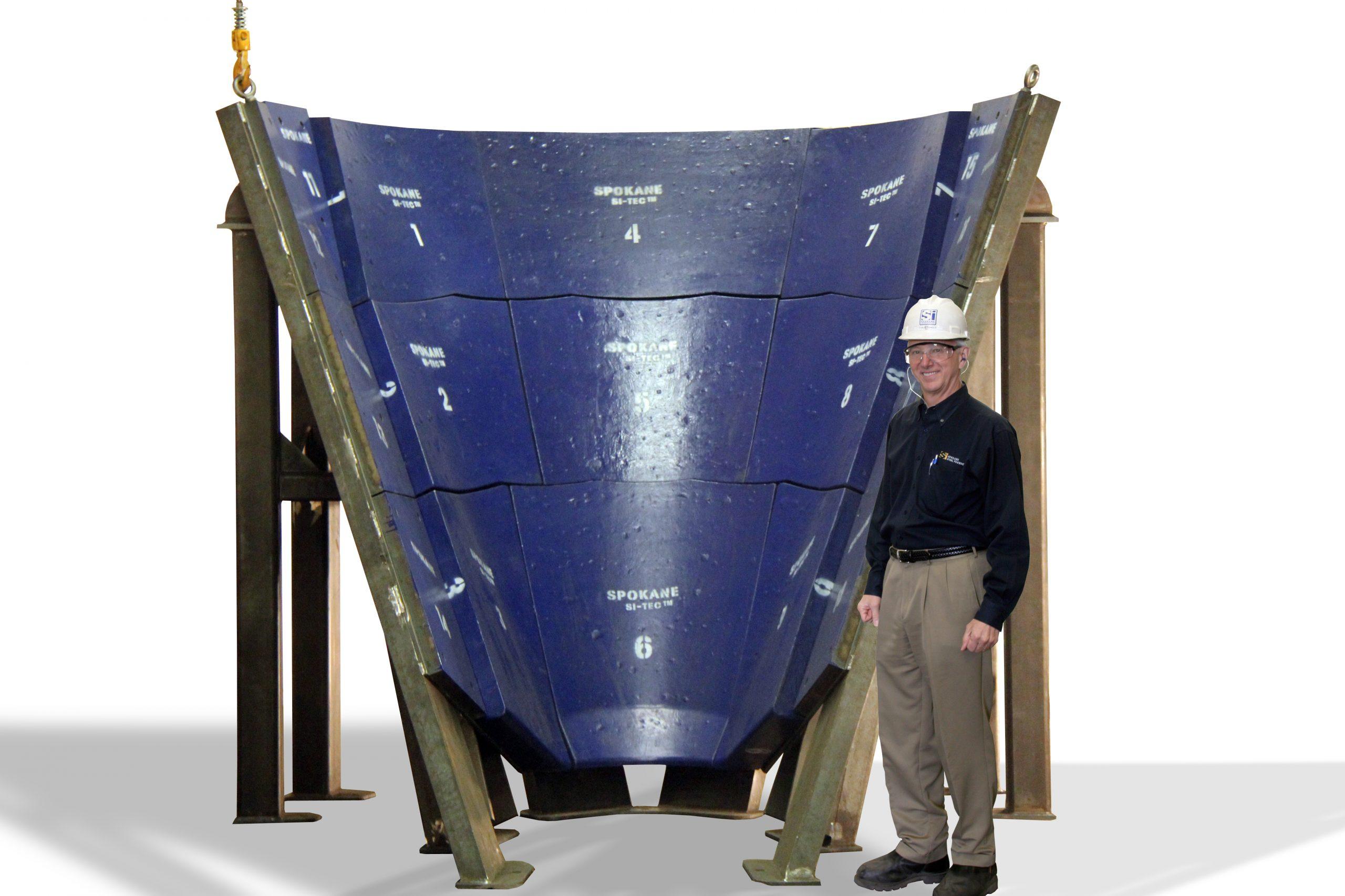 A numbered Si-Tec® chute liner assembly on its lifting frame, standing well over twice the height of the person beside it.