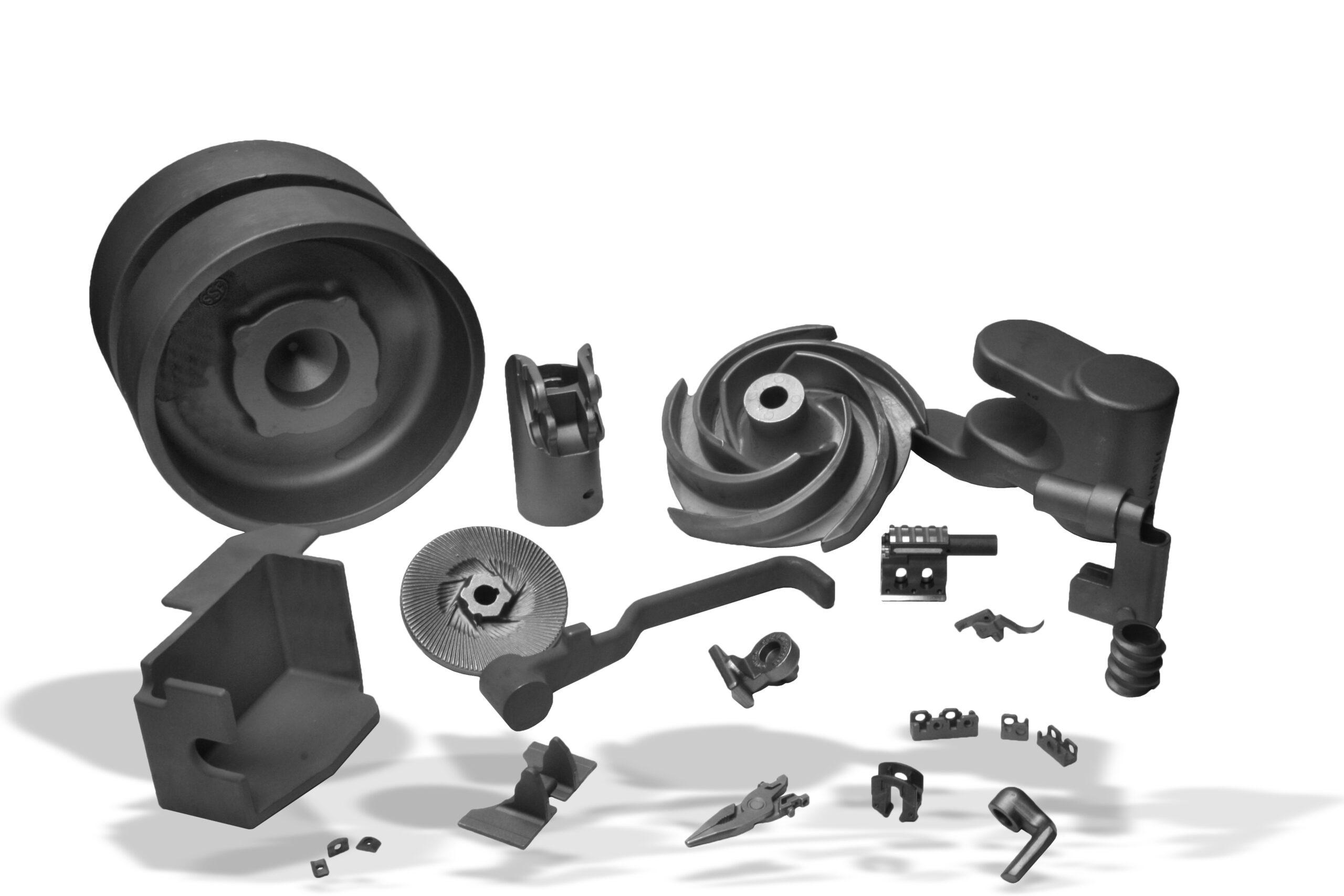 A range of investment castings together: pump housing, impeller, wheel, and small linkage parts.